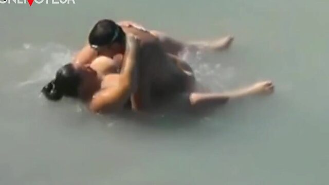 Un tipo filma a una sirena playera siendo golpeada por las olas.